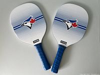 Two Blue Jays pickleball paddles shown from front side, displaying Blue Jays logo and Ryobi branding.