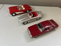 Photo from front and side showing all three cars on white surface