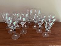 Group photo showing all 14 crystal glasses with the distinctive faceted pattern on the bowls, arranged on a wooden surface