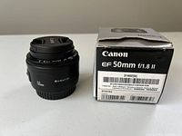 Canon EF 50mm f/1.8 II Lens with cap and original box showing product details and condition.