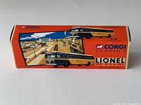 Front side of the original orange box with blue and cream bus illustration and Corgi Classics Lionel City branding, showing the image of the diecast bus model.