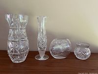All four vases arranged in a row on a wooden surface against a neutral background.