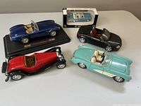 Overview of four diecast model cars showing various colors and boxed Buick model
