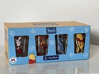 Boxed set of 8 Anchor Hocking juice glasses featuring Winnie the Pooh characters visible through front window of the box.