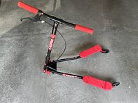 Side angled view of Y Fliker Air A3 drifting scooter showing red grips, two red foot platforms and black frame on concrete floor.