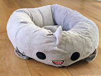 Front view of round gray shark bolster pet bed showing shark face details and plush fabric.