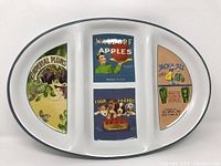 White oval divided serving platter with black rim and vintage labels printed in each section.