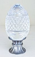Full front view of the vintage solid crystal clear cut glass egg-shaped paperweight on a metal stand, showing intricate diamond and leaf motifs.