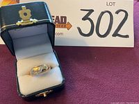 Ring in presentation box showing top view with diamond accents
