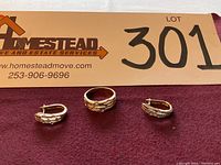 Ring and earrings displayed on purple cloth with lot sign in background