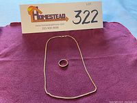 Ring and chain on purple cloth for full lot overview