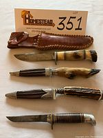All four knives laid out with leather sheath