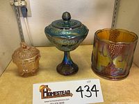 Full view of all three Carnival Glass pieces together: covered wedding bowl, canister cookie jar, and footed candy dish.