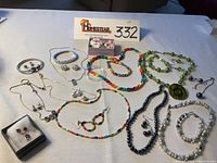 Overview of assorted jewelry including necklaces, bracelets, earrings with some matching sets and colorful beads.