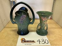 Front view showing the handled freesia basket and lily vase side by side on wooden surface.