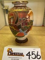 Front view of vintage Satsuma Japan ceramic vase showing handpainted figure of a woman with gold, red, green, and blue colors.