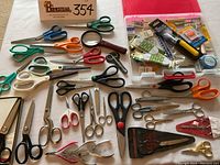 Three images showing a variety of scissors including large shears, small fabric scissors, specialized pinking shears, and an open plastic sewing accessory box containing needles and tools.