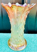 Front view of marigold carnival glass vase with tree trunk texture and ruffled lip, showing iridescent finish and smooth base.