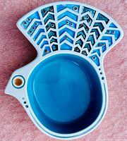 Top view of the ceramic trinket dish shaped like a bird with a detailed blue and turquoise fan-shaped tail decoration and solid blue interior.