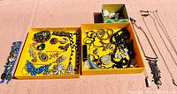 Overview photo showing all jewelry pieces arranged in Givenchy branded trays and boxes on a flat surface