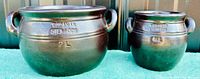 Photo of two vintage Höganäs stoneware crocks, larger 5L and smaller 2L, side by side on green surface seen from front