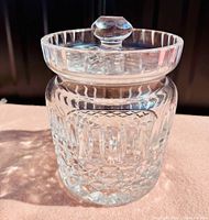 Front side view of crystal biscuit barrel with intricate cut crystal pattern and faceted lid knob.