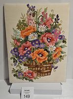 Front view of the vintage floral crewel embroidery showing a colorful basket of flowers on cream fabric.