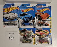 Lot of five Hot Wheels cars in original sealed packaging, including white Acura NSX, blue Ford Focus RS, Speed Dozer, and two others.
