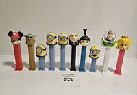 Front view showing all 9 Pez dispensers lined up in a row with variety of characters.
