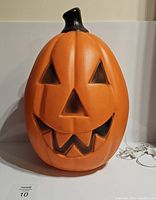 Front view showing the Jack O Lantern facial features and clip light cord to the side.