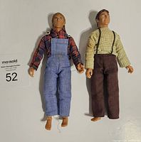 Photo of both Mego Walton figures dressed, showing Pa Walton on left with blue overalls and plaid shirt, Jon Boy Walton on right with green checkered shirt and brown pants.