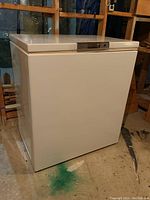 Overall view of white Admiral chest freezer in basement setting.