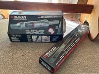 View of vacuum cleaner box showing compact size cordless vacuum and features like bagless, rechargeable, lightweight, powerful motor, maximum suction