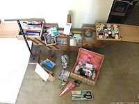 Wide overhead shot of the sewing basket and sewing notions spread out on floor showing contents including threads, scissors, measuring tapes, smaller basket and jar with buttons.