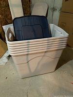 Photo showing six white Rubbermaid Keepers 20 gallon totes stacked with navy blue lids inside.