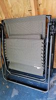 Folded zero gravity lounge chair with woven fabric and sturdy black metal frame.