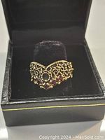 Front view of gold filigree garnet ring in presentation box