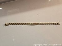 Full view of the yellow gold bracelet laid flat on white surface