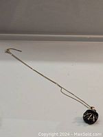 Full-length view of necklace laid flat showing chain and pendant