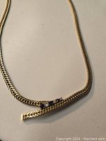 Chain laid flat showing offset sapphire and diamond accent.