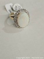 Front view showing oval opal center and surrounding diamond halo