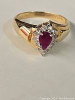 Front view of ring showing pear-shaped ruby and diamond halo