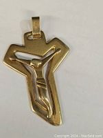 Front view of gold cross pendant showing stylized crucifix figure