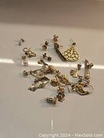 Multiple earrings laid out showing variety of studs and drops