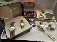 Overview of nine timepieces including boxed wristwatches, leather‐strap watch, two‐tone bracelets, pocket, pendant and ring watches