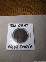 Front side of the 1861 Nova Scotia one cent coin showing '1861 CENT NOVA SCOTIA' handwritten on holder.
