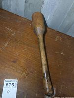 Photo showing full length of the solid maple antique club on a wooden surface.