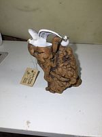 Front view of two ceramic seagulls on a textured burled wood base with original tag visible beside them.