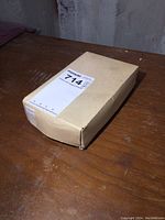 Closed cardboard box containing vintage matchbooks on a wooden surface.