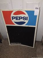 Full view of the vintage Pepsi embossed metal chalkboard sign showing the upper Pepsi logo section in red, white, and blue and the large lower black chalkboard area.